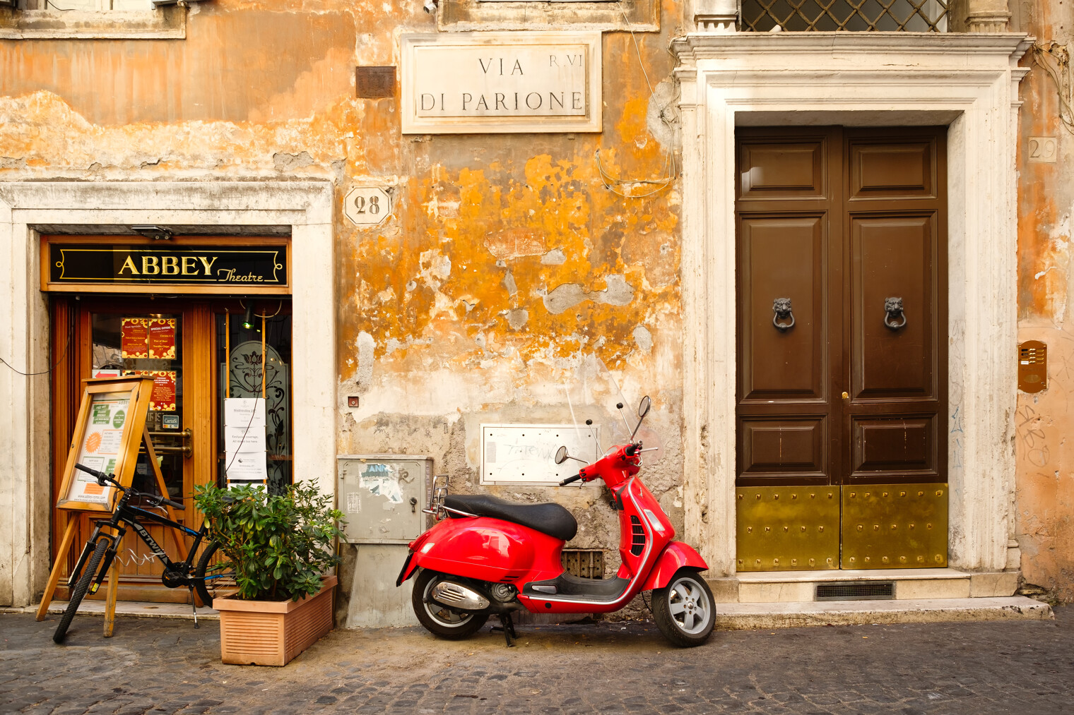 Une rue typique italienne avec un scooter rouge