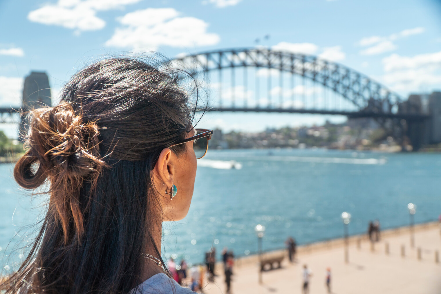 Une femme de dos en train de regarder l'Harbour Bridge de Sydney en Australie