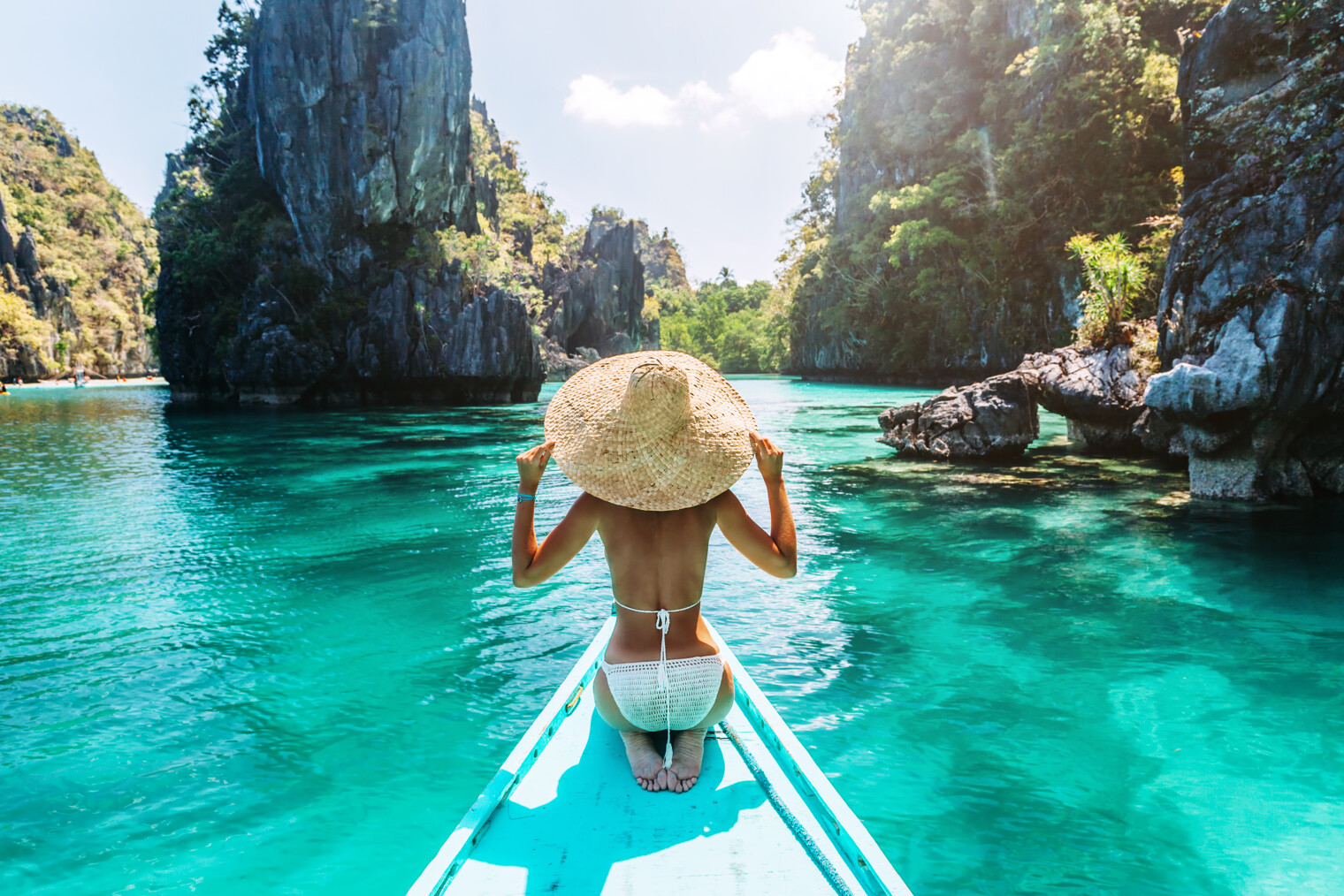 Une femme de dos en maillot de bain sur une embarcation à El Nido, Palawan aux Philippines