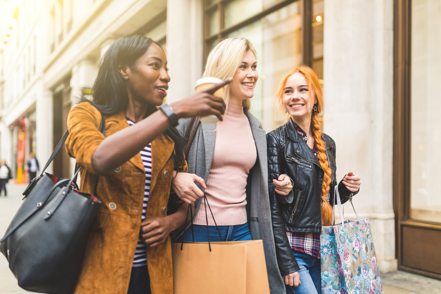 Trois femmes dans la rue avec des sacs de shopping à la main