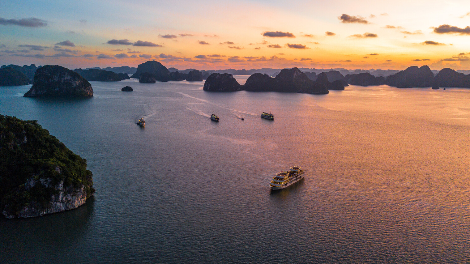 Vue aérienne sur la baie d'Halong et ses bateaux au coucher de soleil