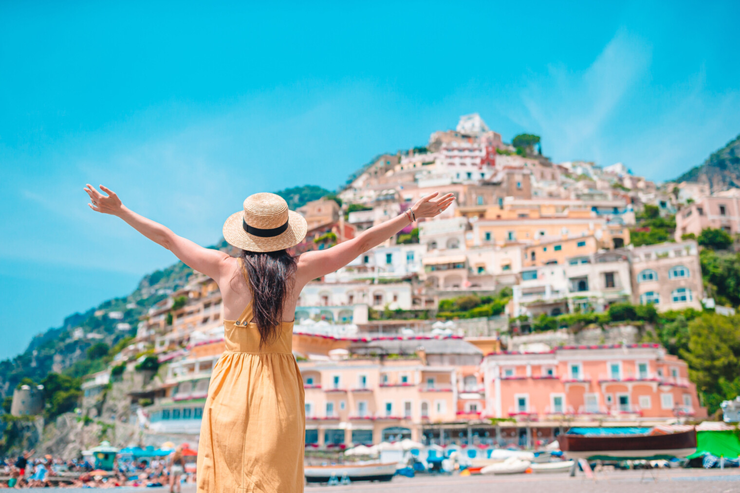 Une femme solo bras en l'air devant la beauté d'Amalfi en Italie