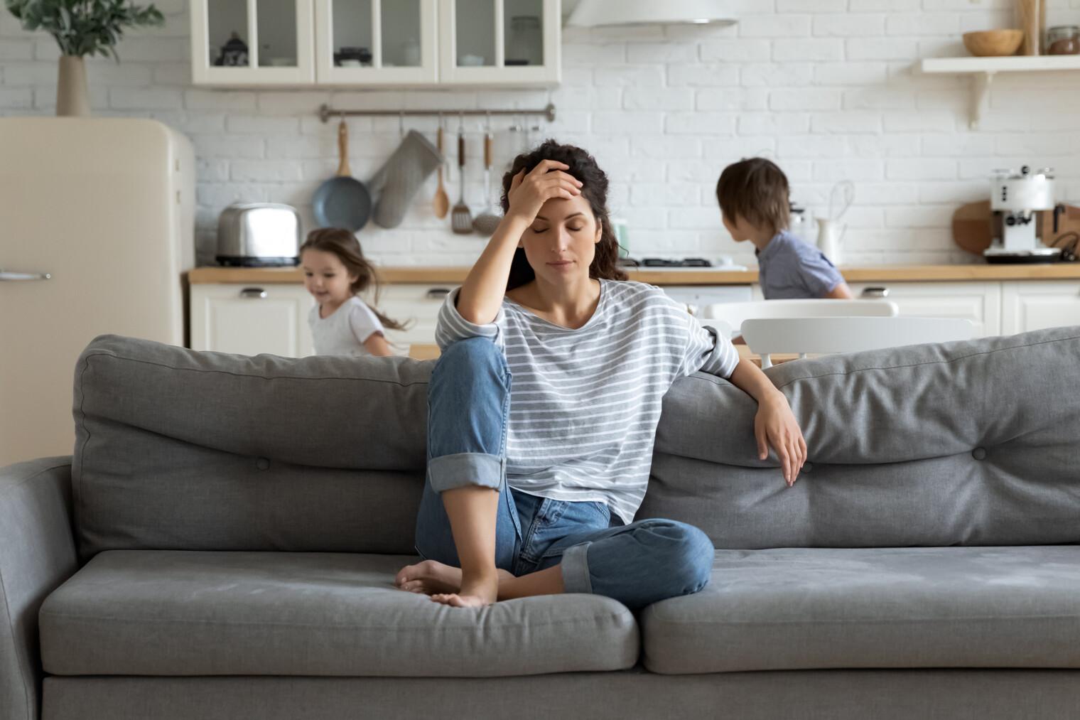 Une mère de famille solo avec ses enfants qui se tient la tête