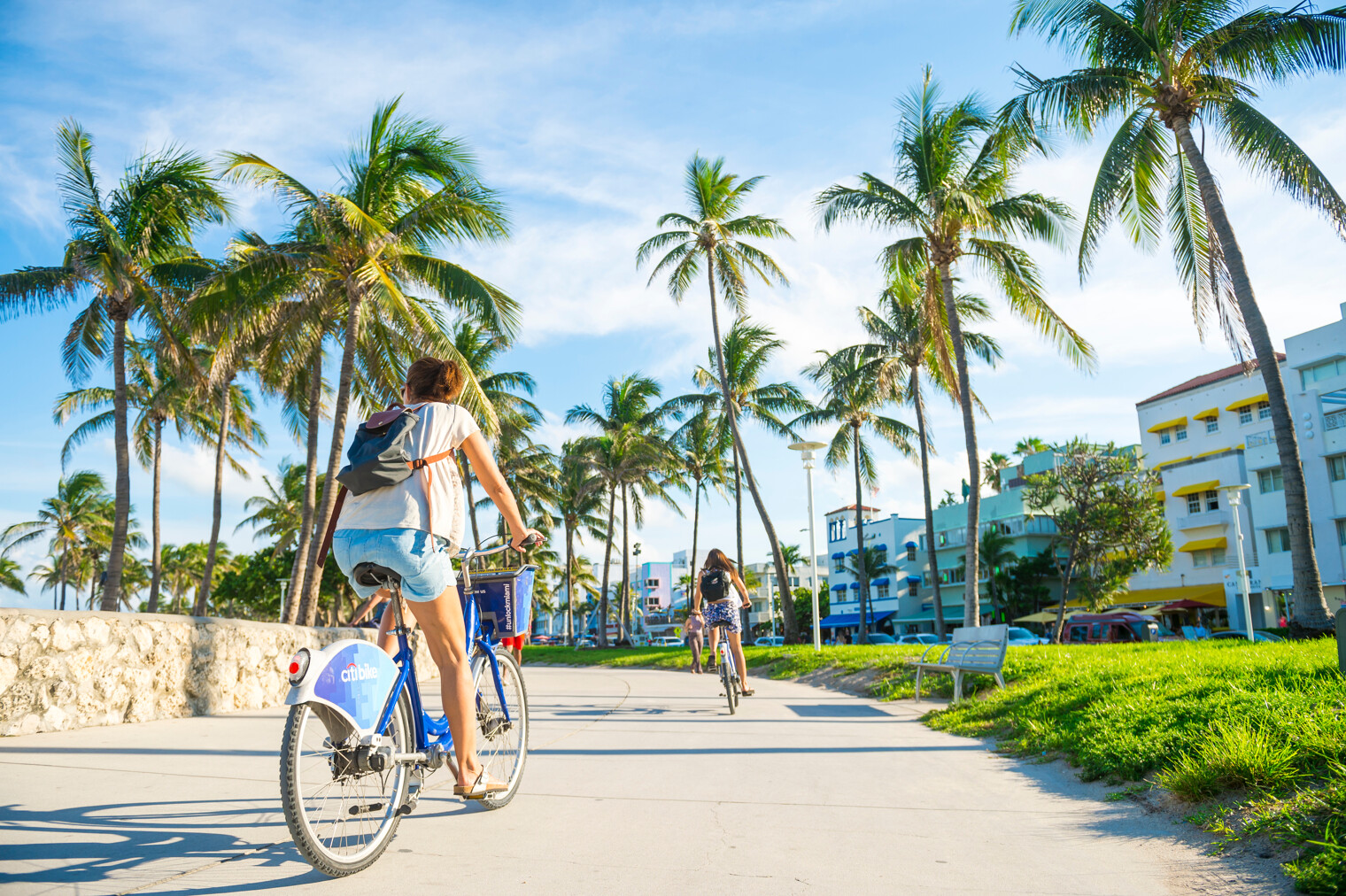 Deux femmes en train de faire du vélo en bord d'océan à Miami, en Floride