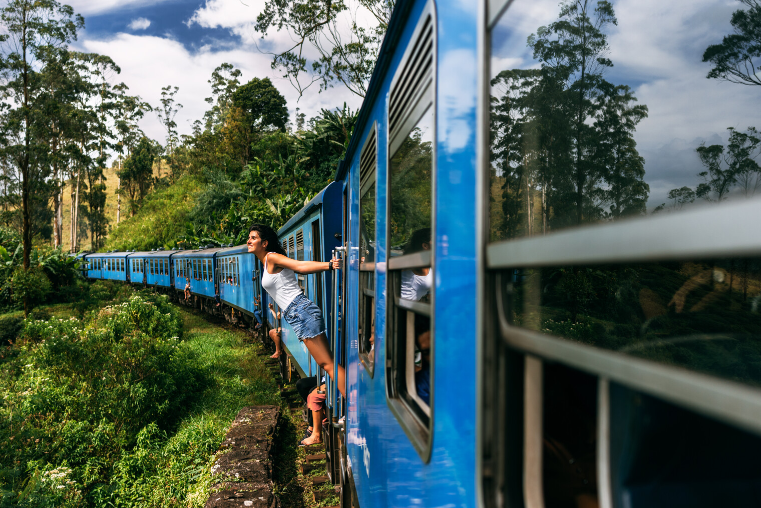 Une femme qui regarde à l'extérieur d'un train en marche au Sri Lanka