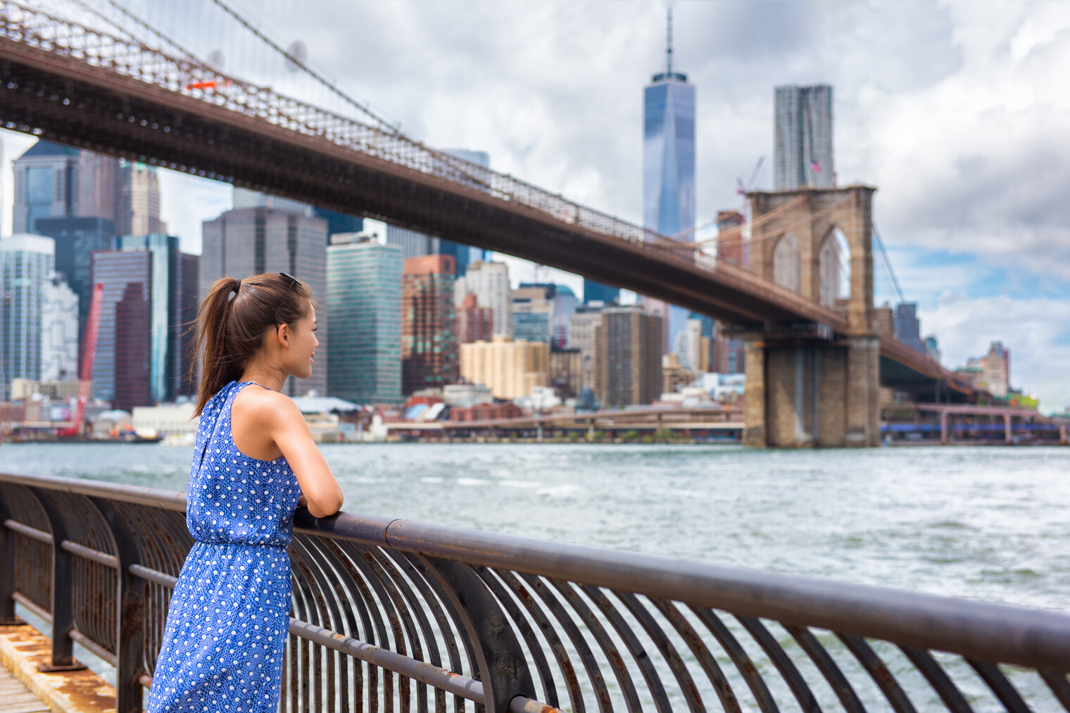 une femme en train de regarder le pont de Brooklyn à New York