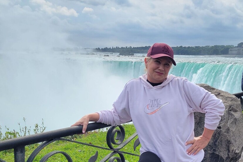 Une femme en rémission du cancer du sein en voyage au Canada devant les chutes du Niagara