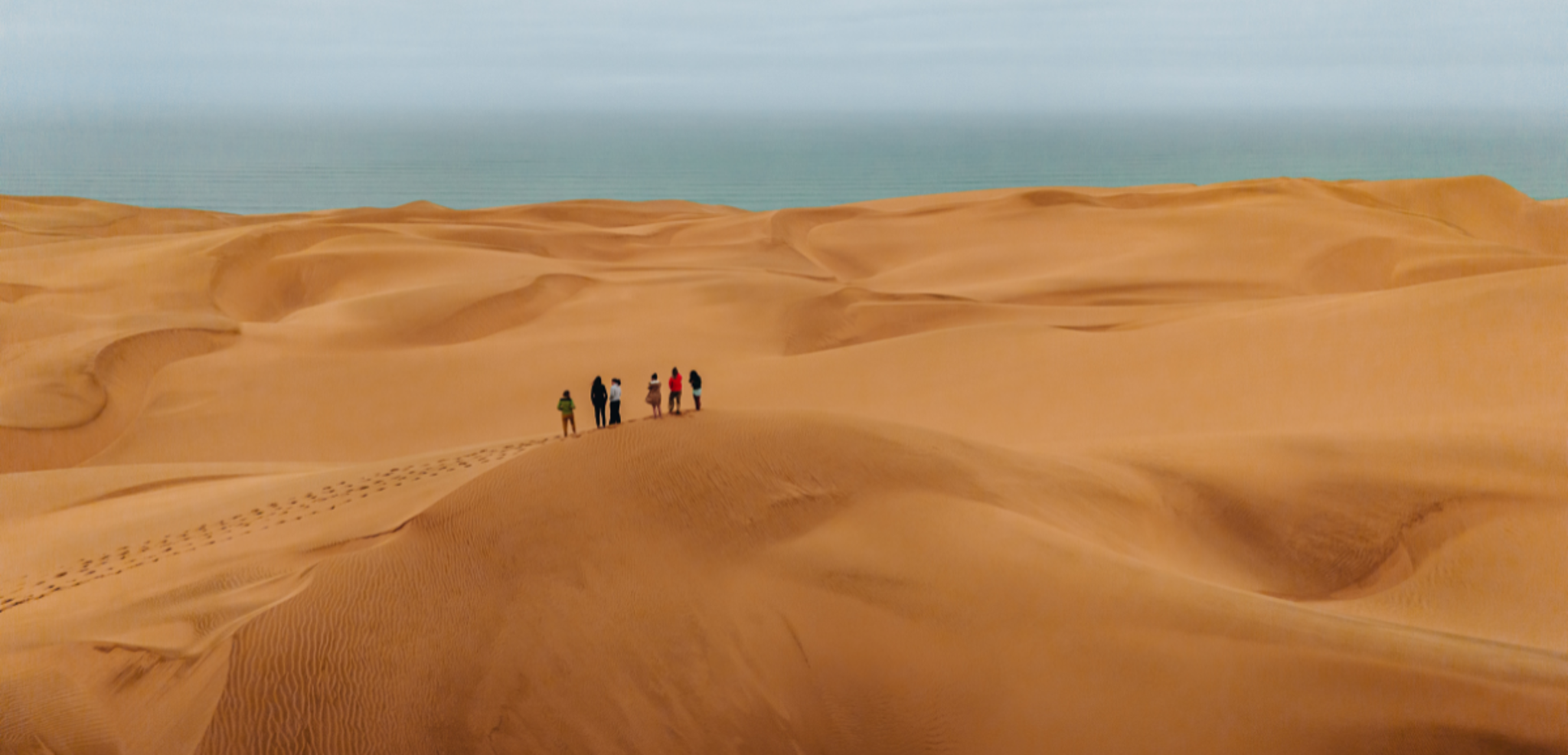 Escaladez les dunes au soleil couchant, avec le sable pour horizon