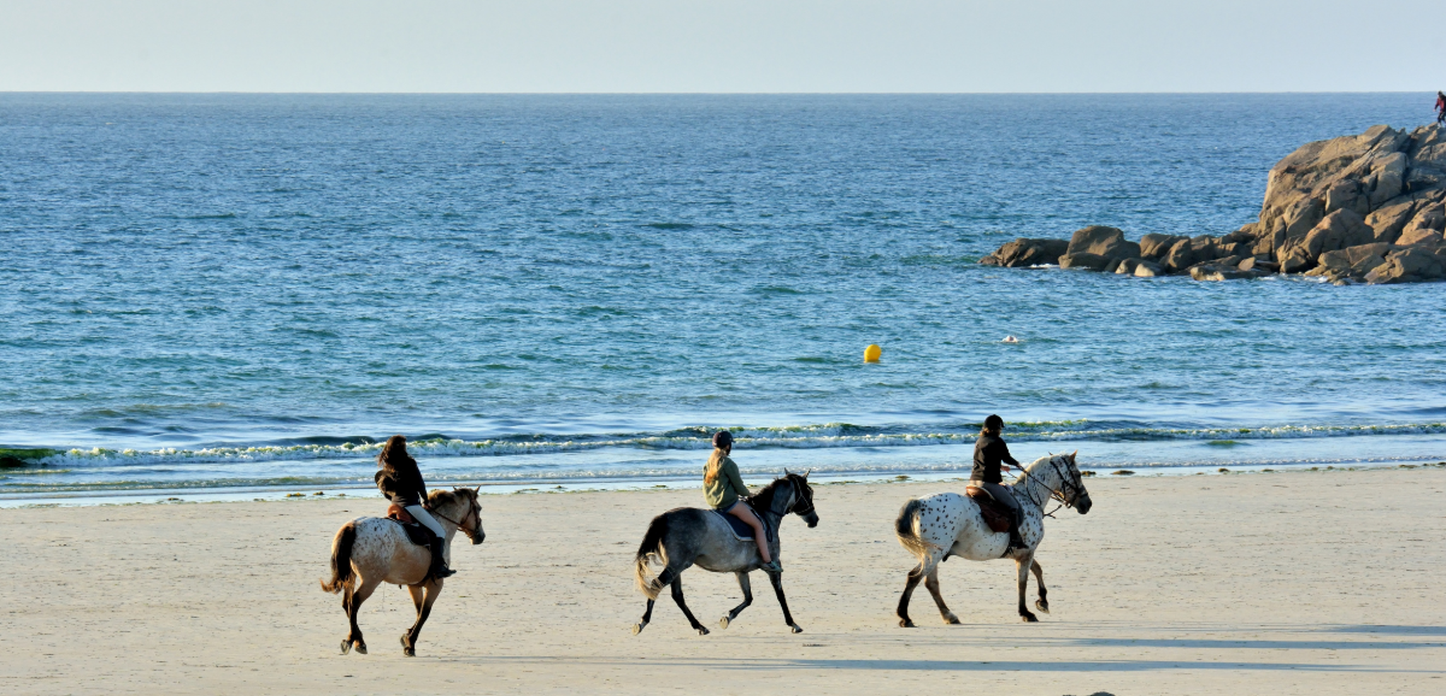 Cheveux au vent, lors d'une balade à cheval sur la plage d’Erdeven