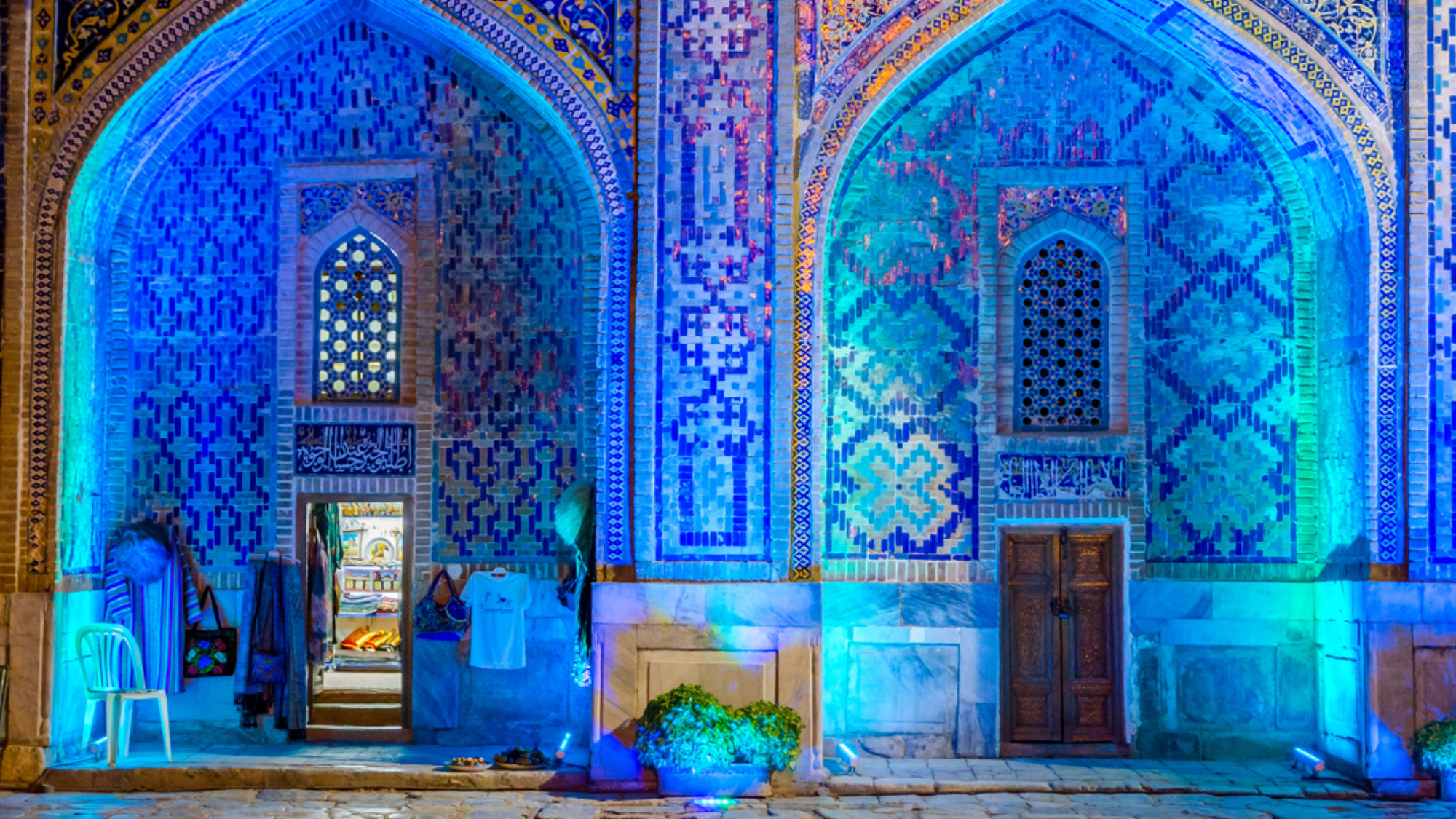 Shopping dans l'atrium éclairé de Sher Dor madrasah la nuit, Registan, Samarcande